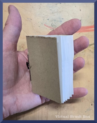 mini handmade book held in a hand for size comparison