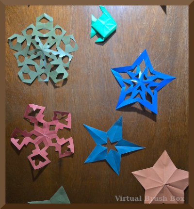 photo of five paper stars and an origami fish on a door