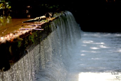 Photo of a water over a short manmade waterfall