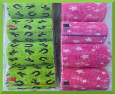 Photo of two sets of flexible bandage sitting on the tailgate of a white truck. One set of wraps is green with black ribbons and horse shoes. The other is pink with stars.