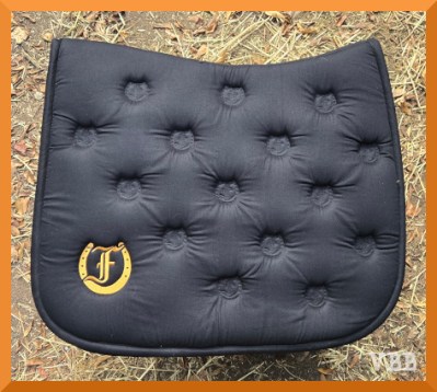 Photo of a black saddle pad with an embroidered logo