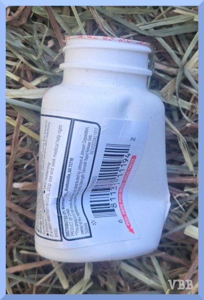 photo of a crushed pill bottle resting on hay