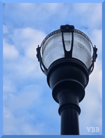 Photo of the top of a lamppost against a cloudy sky