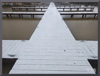 Photo of white-painted wooden docks stretching into background