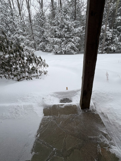 Photo of snow-covered porch with a path partially uncovered