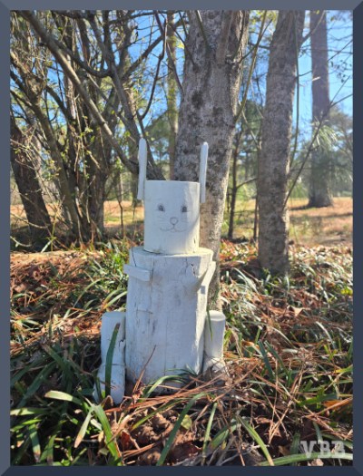 Photo of tree stump with added pieces painted white and turned into a rabbit