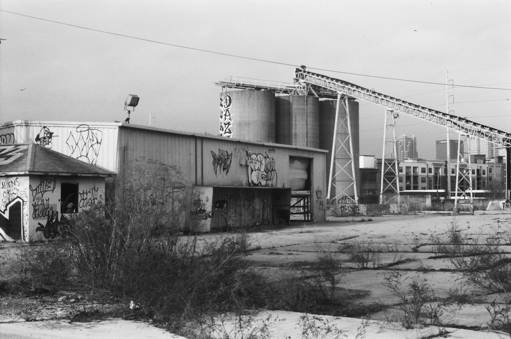 Black and white photo of an old industrial building with silos.