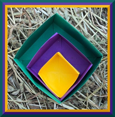 Photo of three paper boxes folded in yellow, purple, and green papers, with the colors repeating in photo border.
