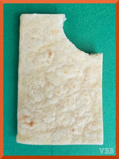 Edible book with bite takes out of the top right corner, resting on green paper.