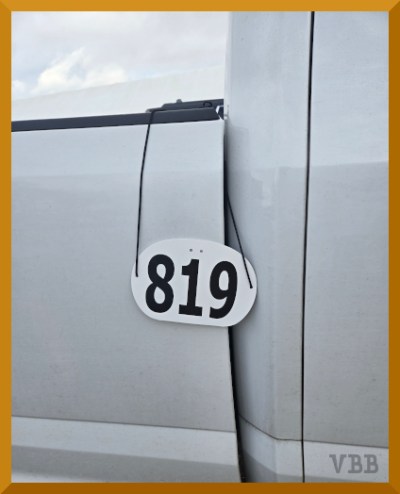 photo of a horse show number hanging off of a white truck
