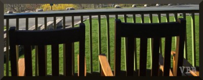 Photo of a wooden railing and two wooden chairs