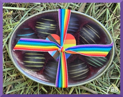 Photo of a small box of chocolates tied with a rainbow ribbon
