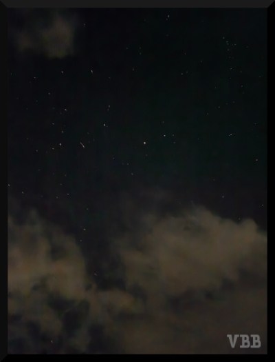 Photo of night sky with stars and clouds.