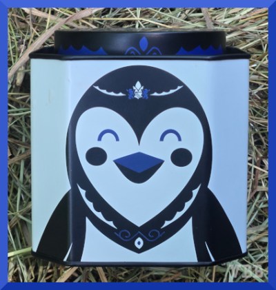 Photo of a metal tea tin picturing a stylized penguin head.