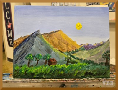 Photo of landscape painting on a metal easel.