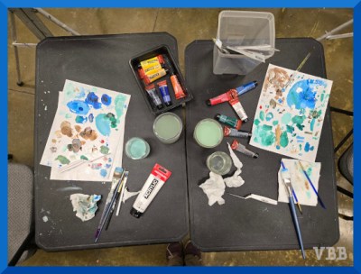 Photo of a table with art supplies in use.