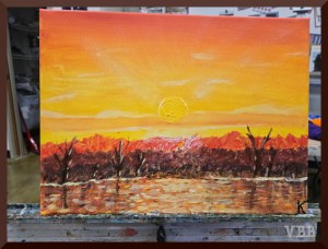 Photo of painting of an orange sunset reflecting in a lake in the foreground
