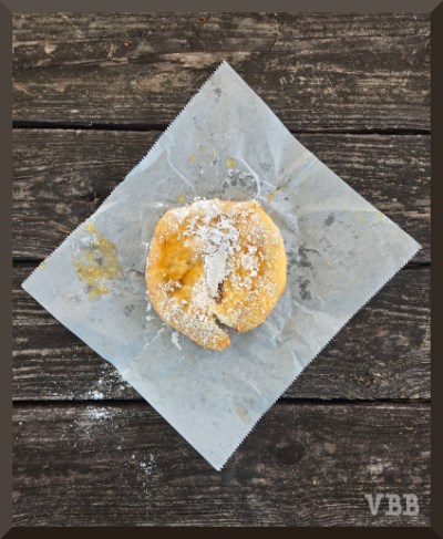 Photo of a round fry bread on waxed paper on a wooden picnic table.