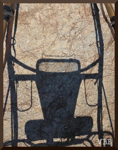 Photo of the shadow of a jog cart on the ground between the shafts.